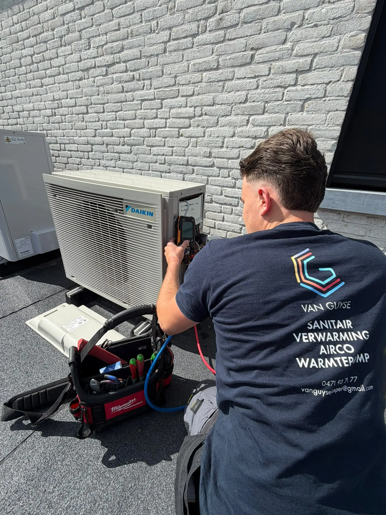 Jasper Van Guyse monteert een Daikin buitenunit aan een woning in het Waasland